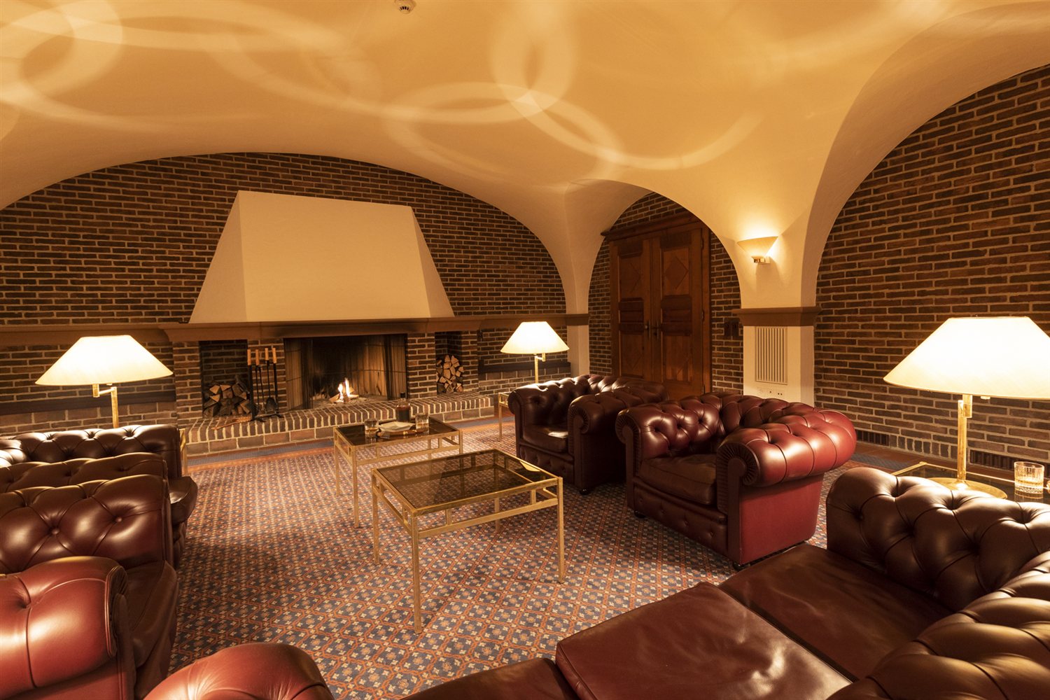 Taverne · Chesterfield-Lounge mit Kamin im Gewölbe