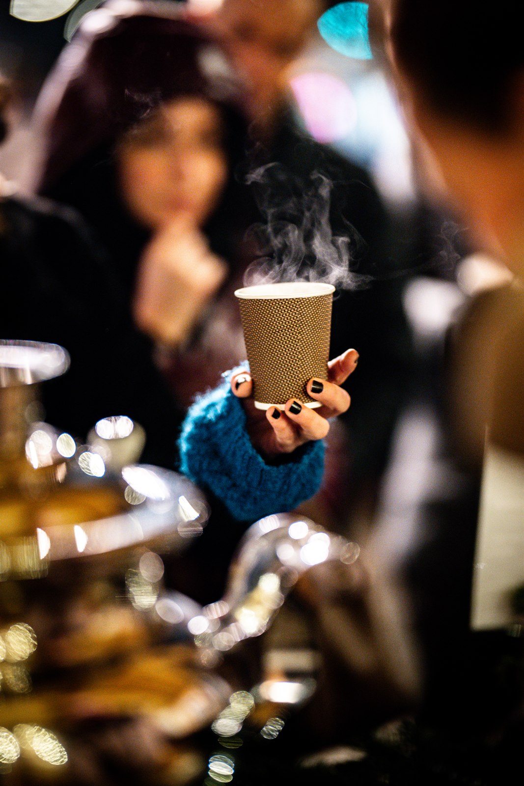 Dampfender Becher Glühwein in der Hand am Outdoor-Apéro von Eve's Christmas Kitchen